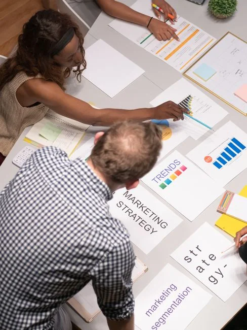 Primo piano di vari documenti di marketing su una scrivania, ideale per conversazioni su business e strategia.